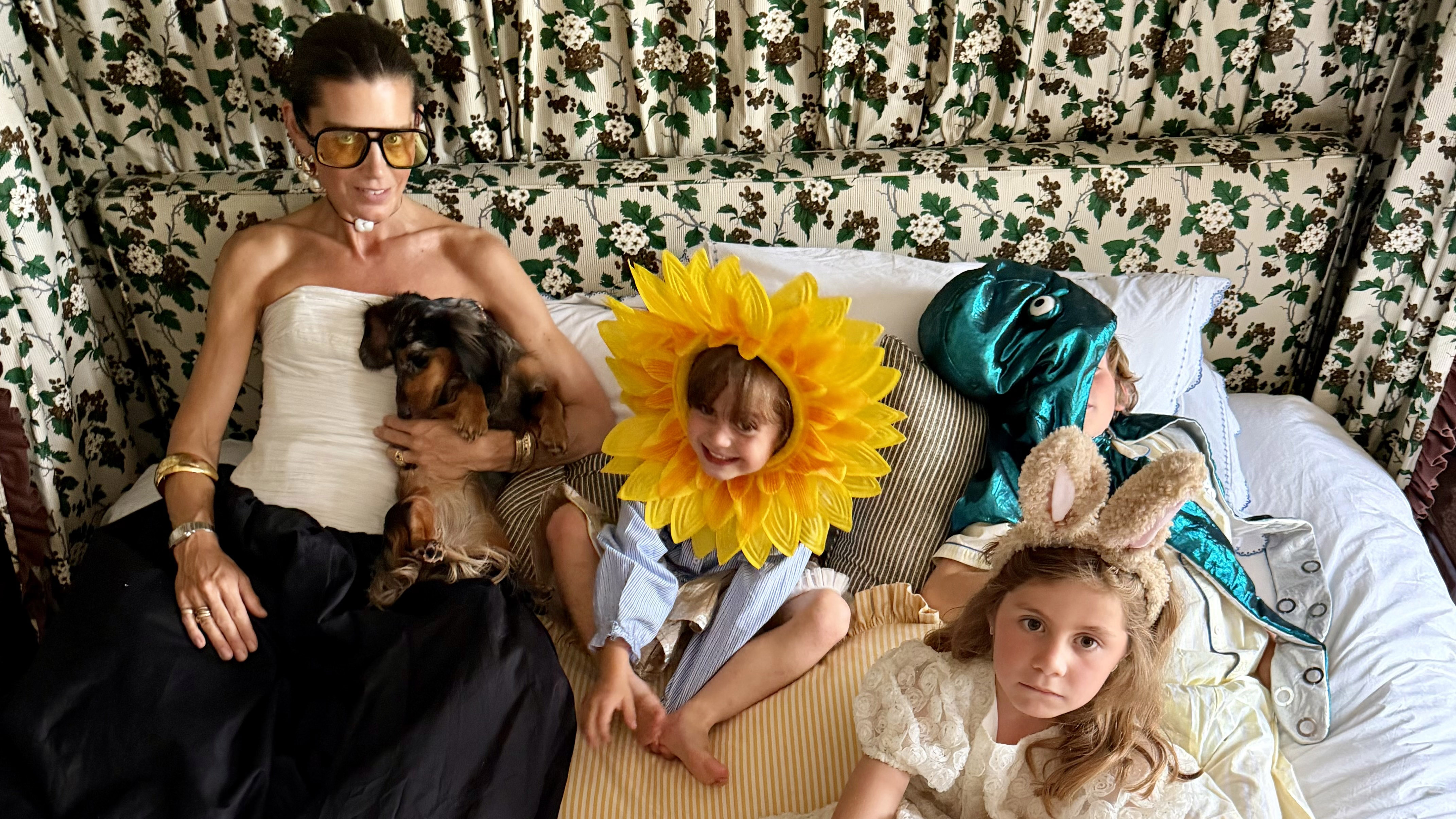 Sarah Corbett-Winder, her three children and a sausage dog lounging on a bed