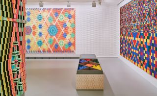 art display of a mosaic like wall with differnt colored pieces that can be added to