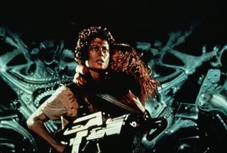 Aliens - Sigourney Weaverâ€™s Ripley protects young survivor Newt (Carrie Henn) in James Cameronâ€™s sci-fi action blockbuster.