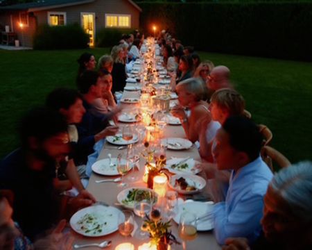 candlelit dinner table with people around it