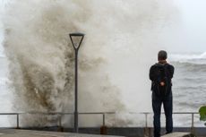 A man looks at the waves at the malecon during high tide after Hurricane Beryl in Santo Domingo on July 2, 2024.