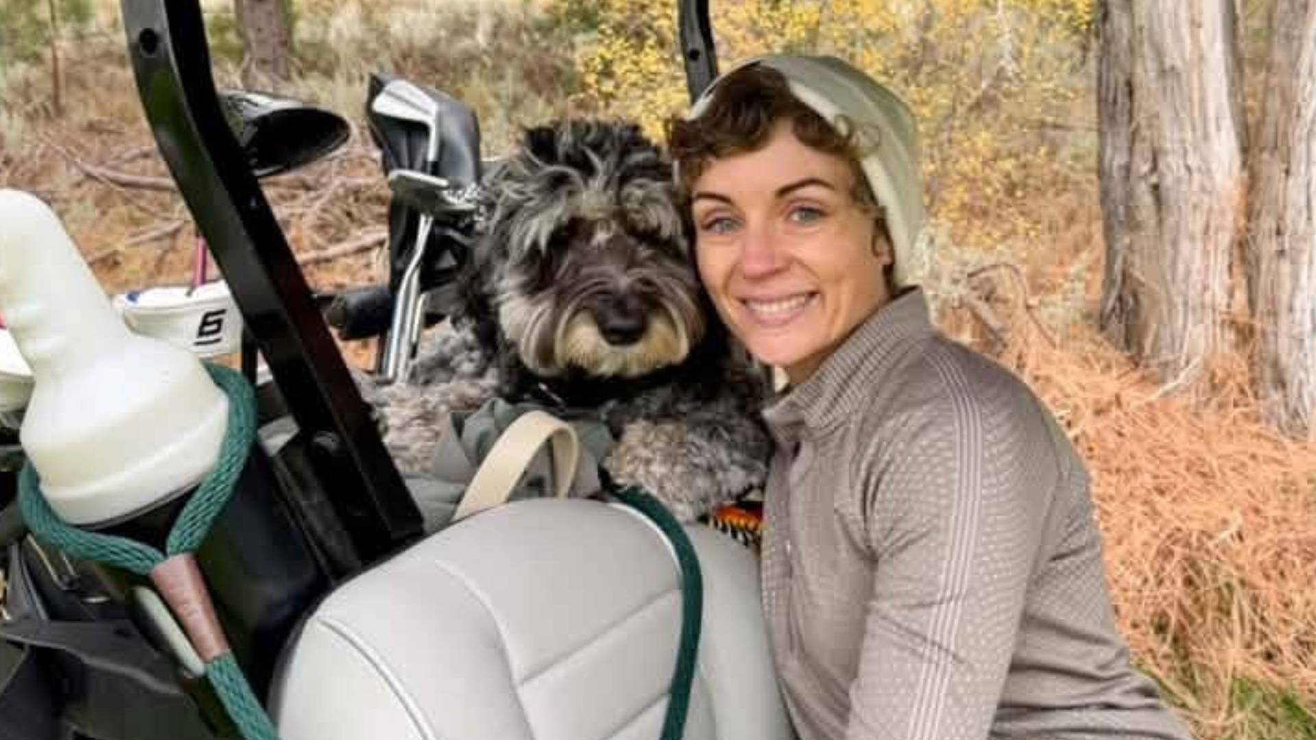Female golfer with her dog in a golf cart