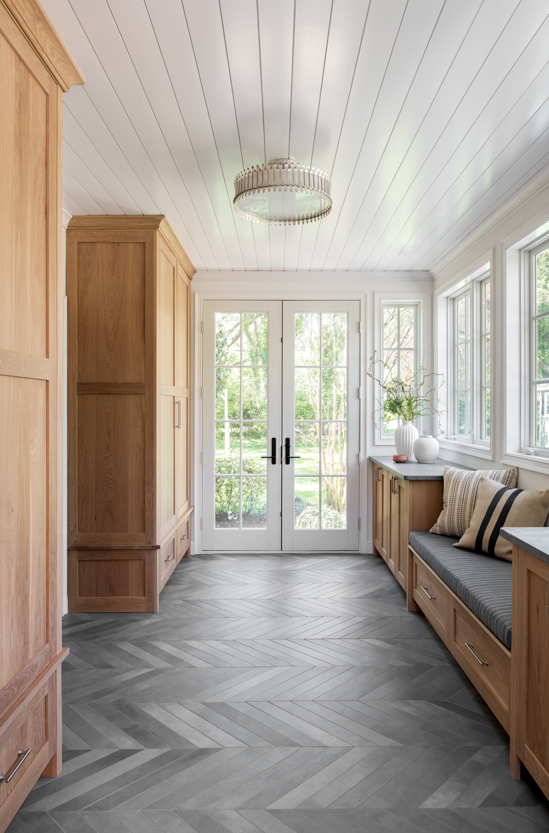 entryway storage with big built in cabinets and a bench within