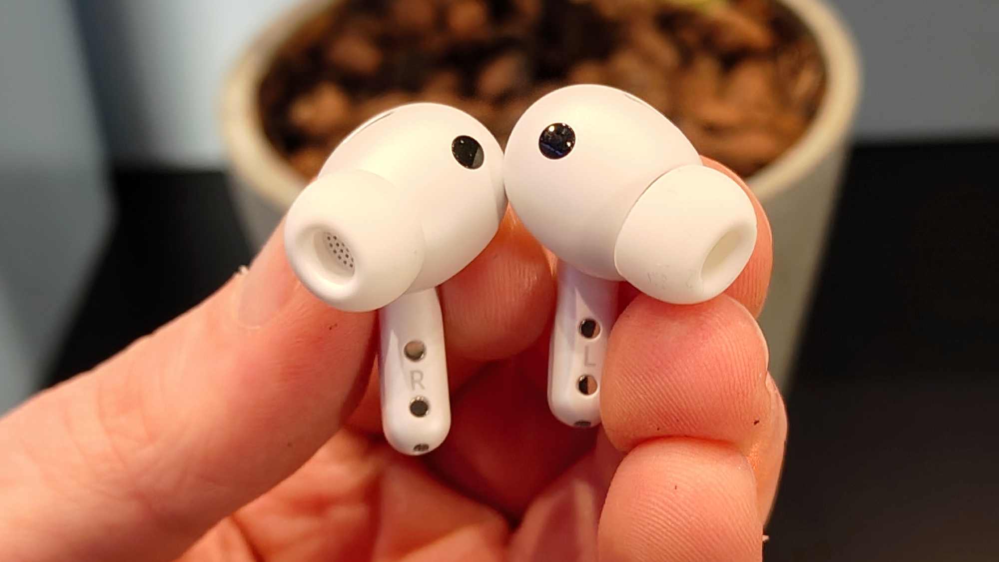 Two The Samsung Galaxy Buds 4 Pro in a man's hand.