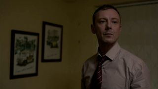 John Simm as Marcus Farrow wearing a shirt and tie and looking off camera in Prey.