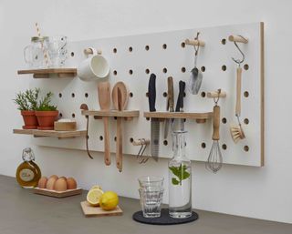 pegboard with utensils and herbs on