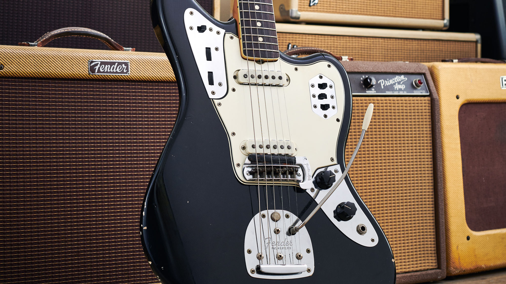 Fender Custom Shop Jaguar and Telecaster in front of a wall of amps