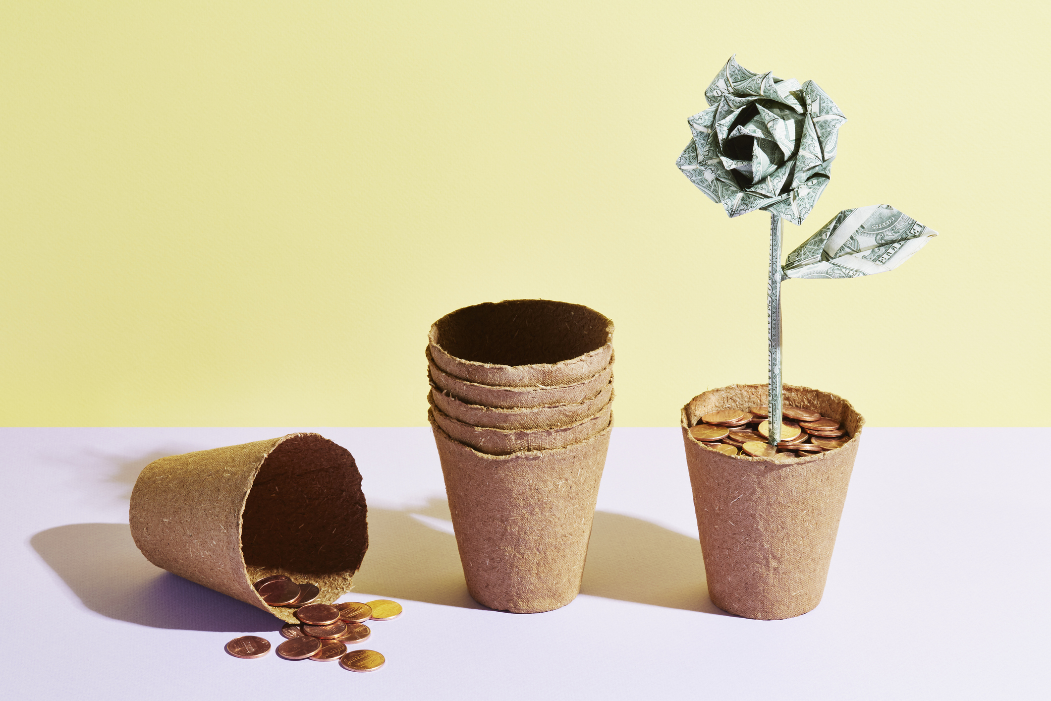 a flower pot with coins, a stack of pots and an origami dollar flower
