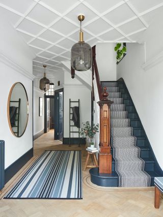 striped runner on black staircase in period property