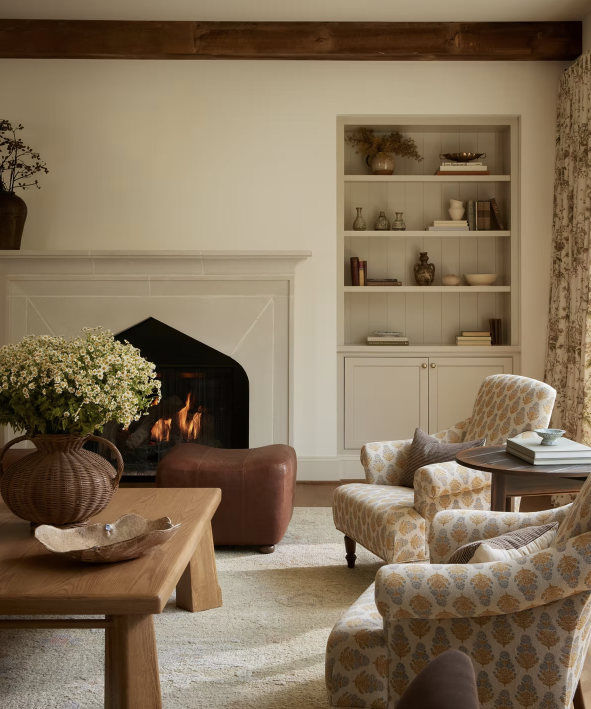 neutral living room with fire and patterned armchairs