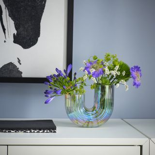 A side table with a mother of pearl curved glass vase