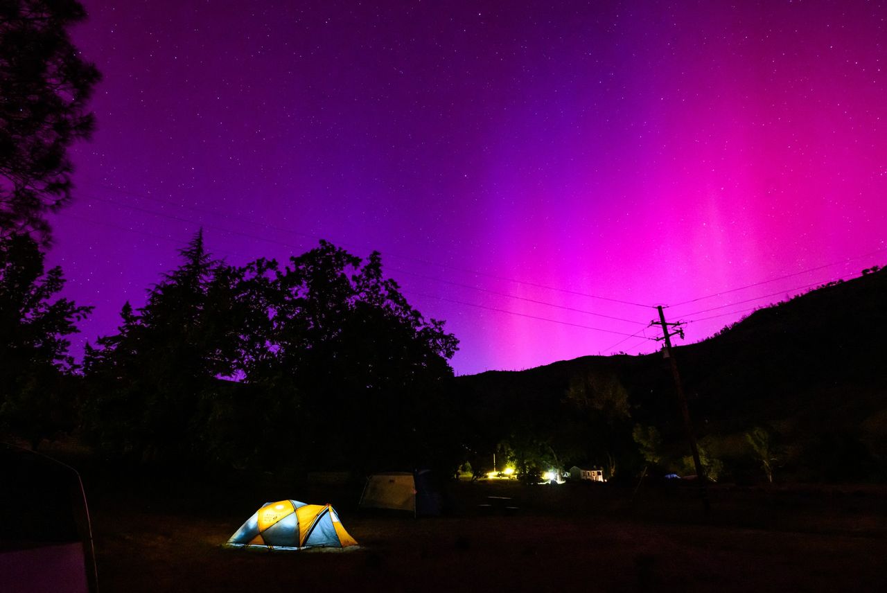 Northern lights or aurora borealis illuminate the night sky over a camper's tent north of San Francisco in Middletown, California on May 11, 2024. The most powerful solar storm in more than two decades struck Earth, triggering spectacular celestial light shows from Tasmania to Britain -- and threatening possible disruptions to satellites and power grids as it persists into the weekend.