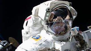 a woman in a white spacesuit walks in space outside a space station