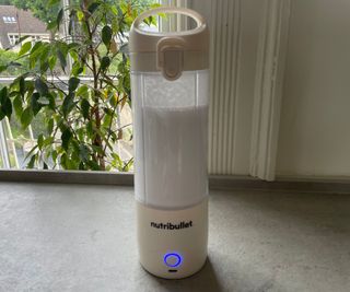 Cleaning the Nutribullet Portable Blender by filling it with water and dishsoap