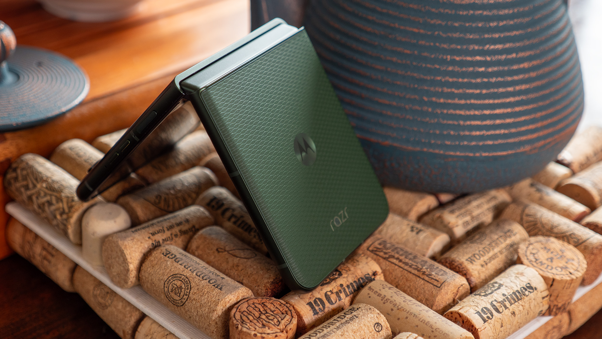 A green Motorola Razr Plus 2026 in tented mode, showing the vegan leather back