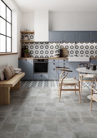 A blue kitchen with patterned tiles as backsplash and flooring