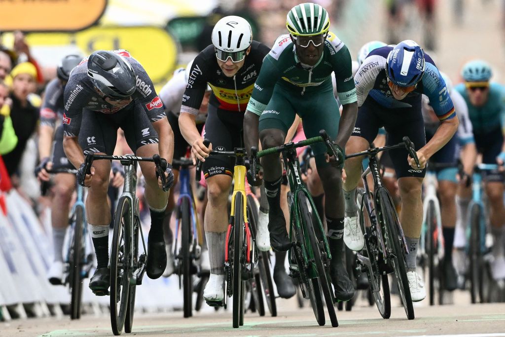 Intermarche - Wanty team's Eritrean rider Biniam Girmay (2nd R) wearing the sprinter's green jersey sprints the finish line to win ahead of second-placed Alpecin-Deceuninck team's Belgian rider Jasper Philipsen (L) and third-placed Lotto Dstny team's Belgian rider Arnaud De Lie (2nd L) during the 8th stage of the 111th edition of the Tour de France cycling race, 183,5 km between Semur-en-Auxois and Colombey-les-deux-Eglises, on July 6, 2024. (Photo by Marco BERTORELLO / AFP)