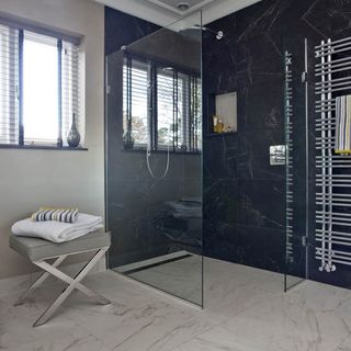 white tiled bathroom with towel rack and shower area
