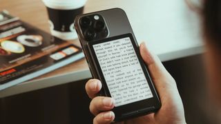 The Xteink X4 ereader clipped to the back of an iPhone 