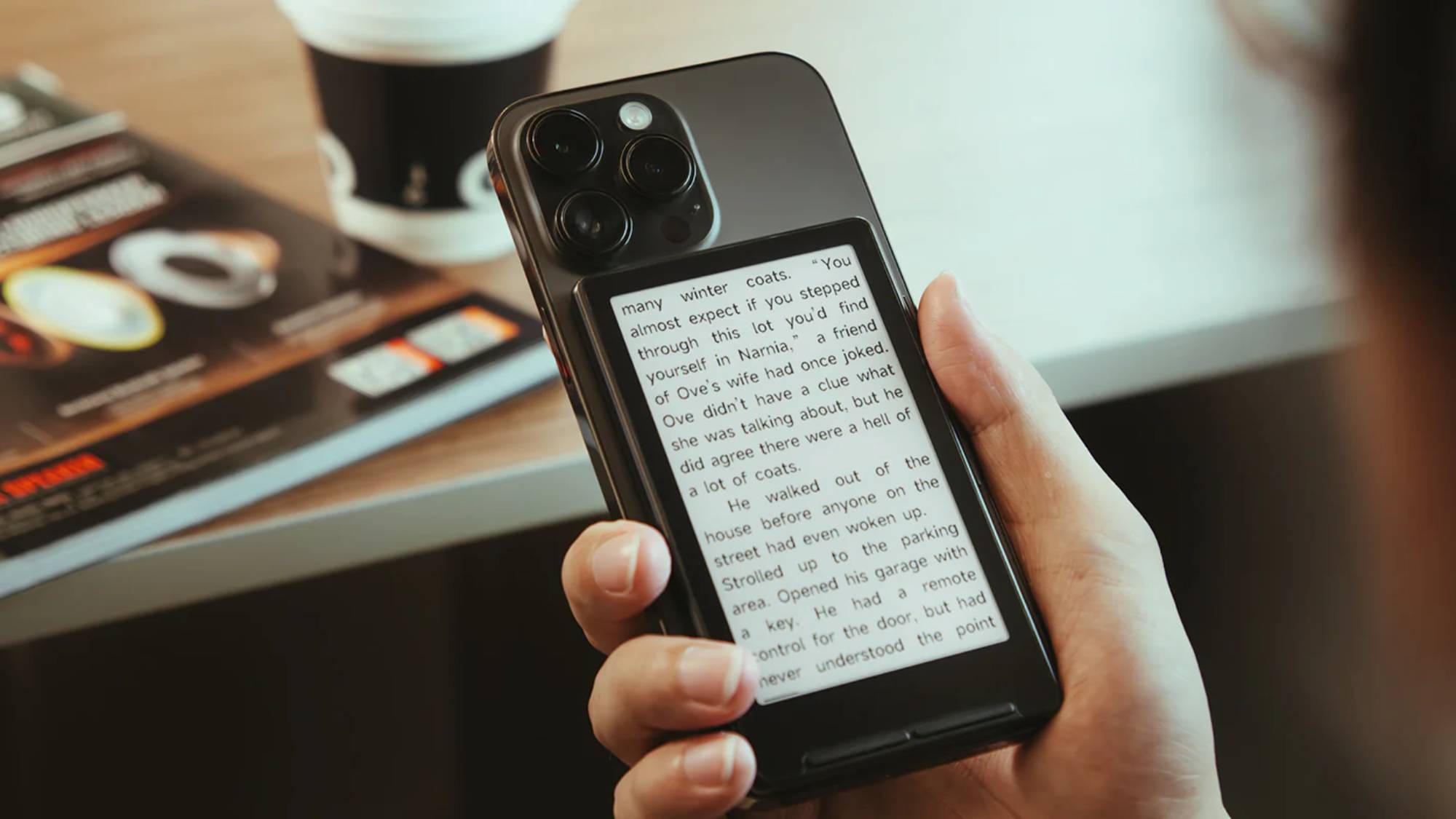 The Xteink X4 ereader clipped to the back of an iPhone 
