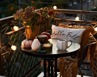 a balcony in the evening with fall decor and flowers