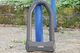 Diamond rated granit super extreme from german brand Abus, leant up against a bike rack.