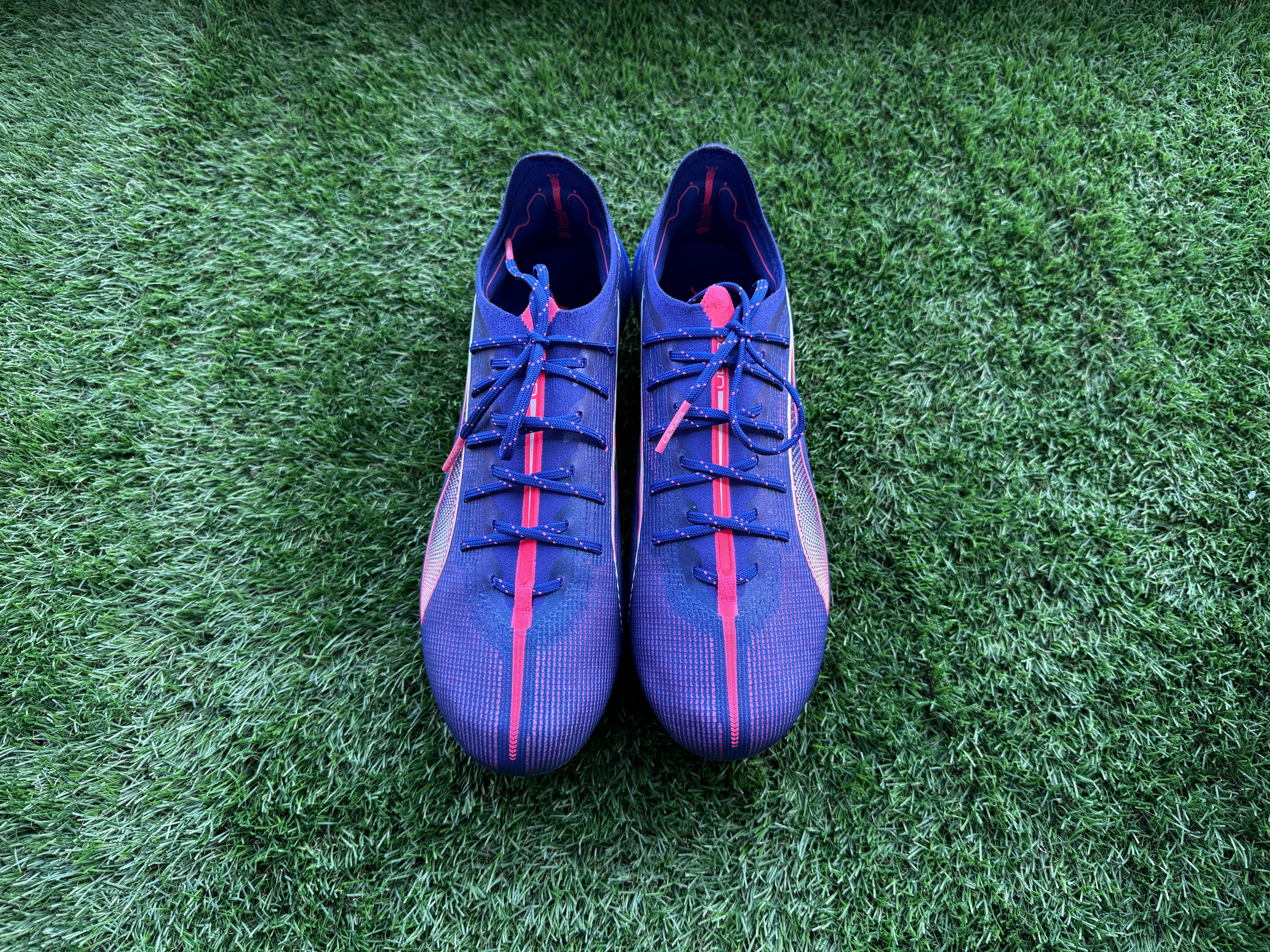 Puma Ultra 5 Ultimate football boots placed on a piece of astro turf for reviewing