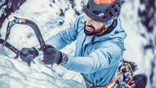 COROS VERTIX review: man climbing a snowy cliff-face with a snow pick