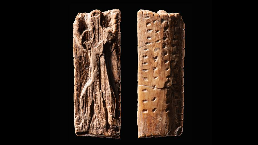 two sides of a carved piece of ivory featuring a human figure on one side and a linear series of notches on another