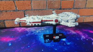 Lego Tantive IV set on a starry background, in front of a brick wall