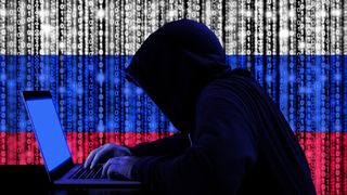 Abstract silhouette of a computer hacker in front of a Russian flag