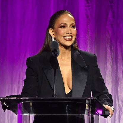 jennifer lopez speaks on stage at an event