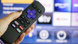 Roku remote with a Netflix button among others in front of a TV.