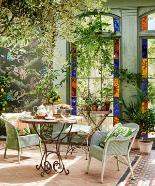 Green conservatory idea by Period Living with stain glass window decor