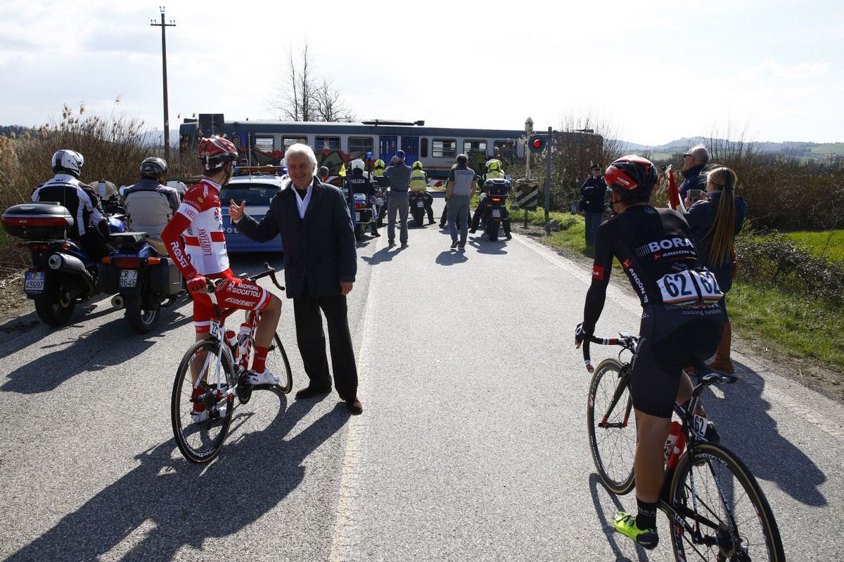 Gianni Savio makes the most of opportunity to chat with his riders who are wait for the train to pass at the level crossing
