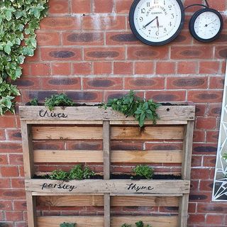 diy wooden pallet herb planter and clock on brick wall
