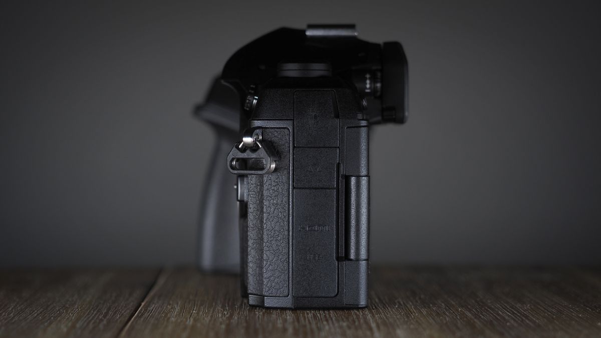 OM System OM-1 Mark II on a wooden surface, against a dark background