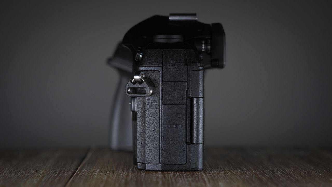 OM System OM-1 Mark II on a wooden surface, against a dark background