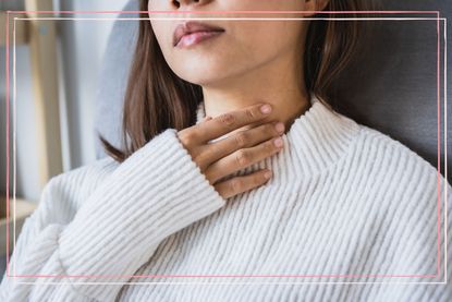 A close up of a woman holding her hadn to her throat to illustrate natural cough remedies