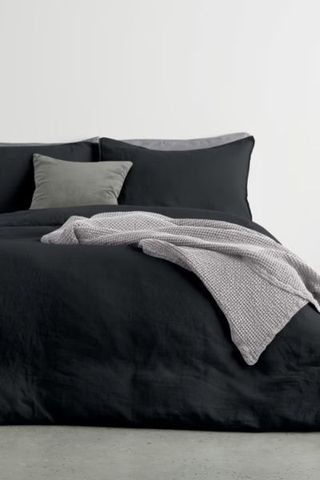 Black linen bedding on bed with throw 
