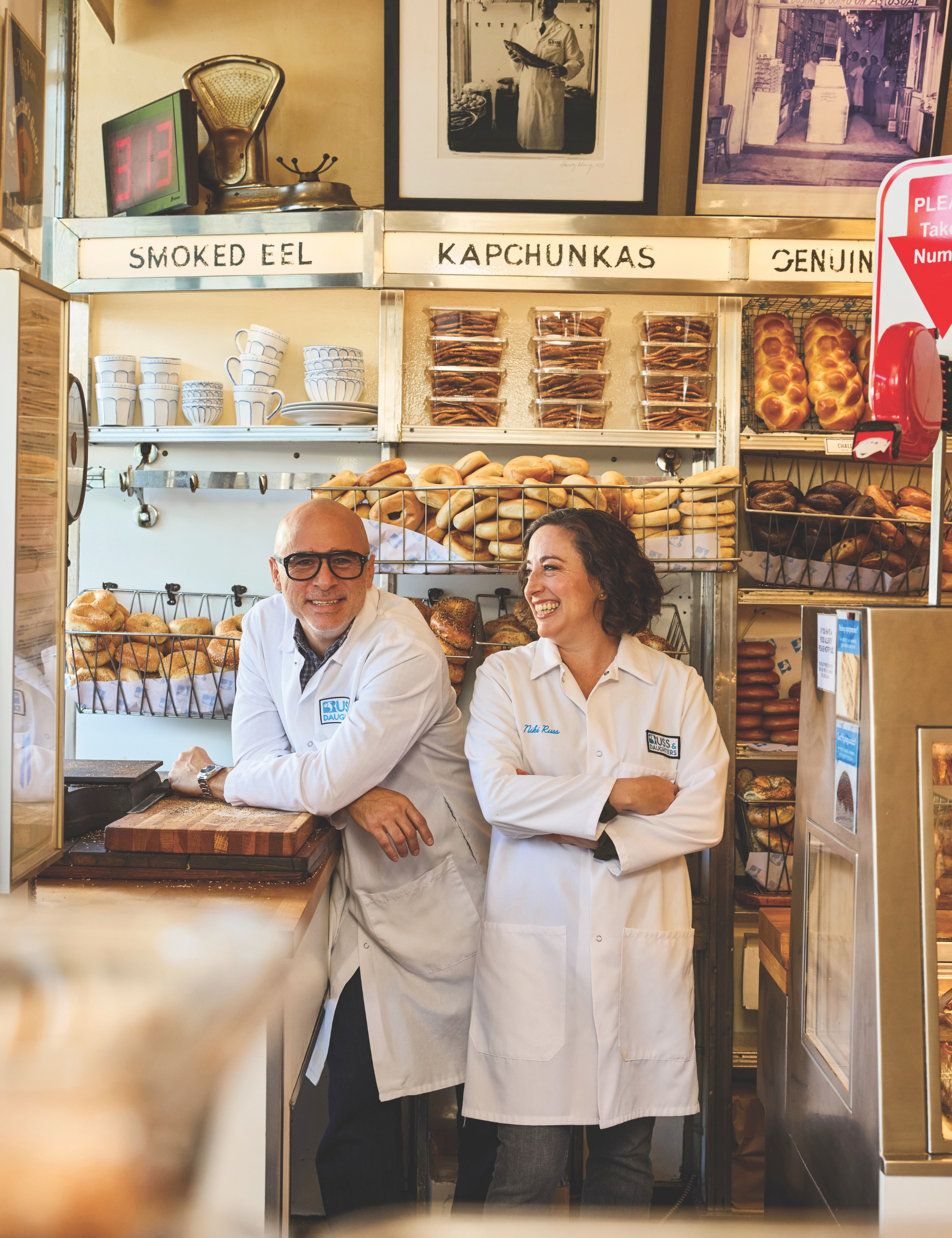 Fourth-generation Russ &amp;amp; Daughters owners Niki Russ Federman and Josh Russ Tuppe smiling in the legendary appetizing store's original Lower East Side Location