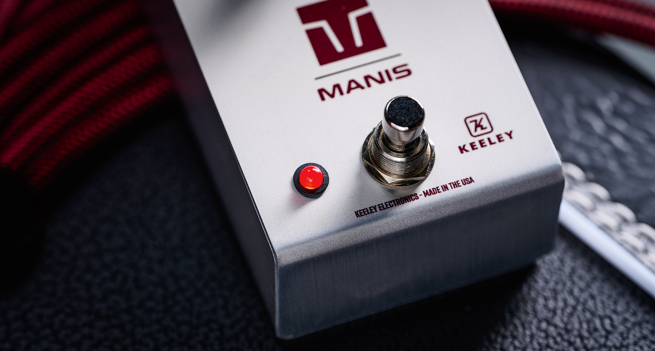 Keeley Electronics Manis: this ingenuous twist ont he K-style overdrive has three-knobs, a couple of mode switches, a tidy white finish and is photographed here against an amp with a red guitar cable.