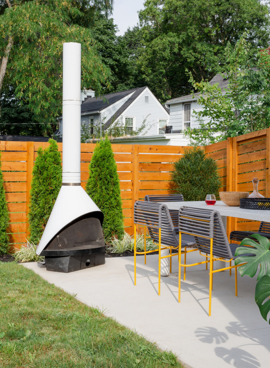 an outdoor dining area with sculptural seats and a fireplace