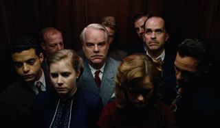 Rami Malek, Amy Adams, Phillip Seymour Hoffman, and Joaquin Phoenix stand in a crowded elevator in The Master.