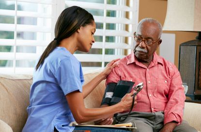 Nurse Visiting Senior Male Patient At Home