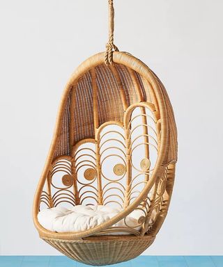 A rattan egg chair with peacock-shaped detail