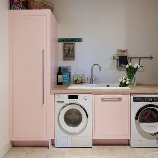pink utility room design with appliances sink and storage