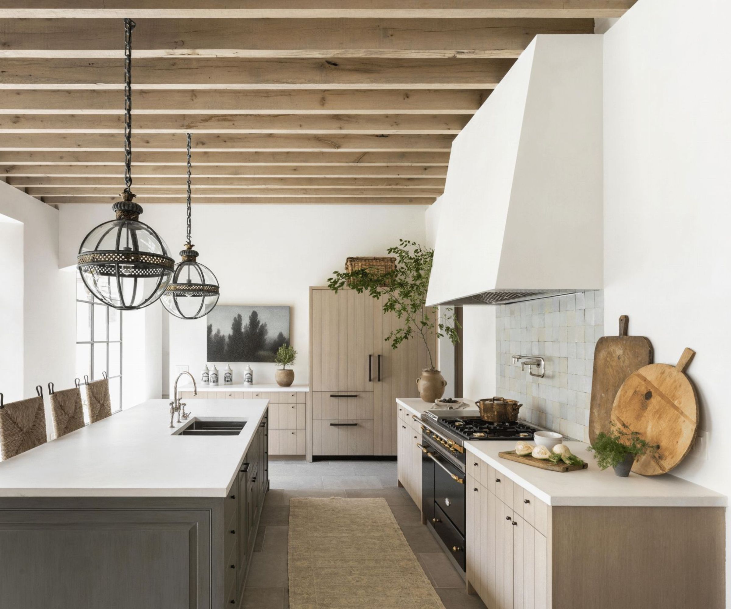 A neutral kitchen with mushroom color cabinets, white walls, and natural wood accents