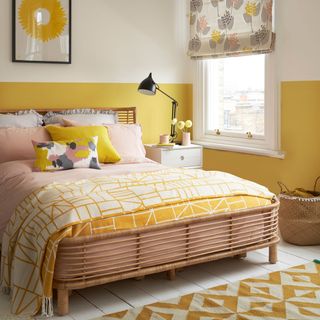 Yellow and white painted bedroom with wooden double bed