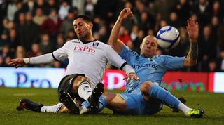 Fulham's Clint Dempsey wins a penalty in a challenge by Tottenham's Alan Hutton in January 2011.